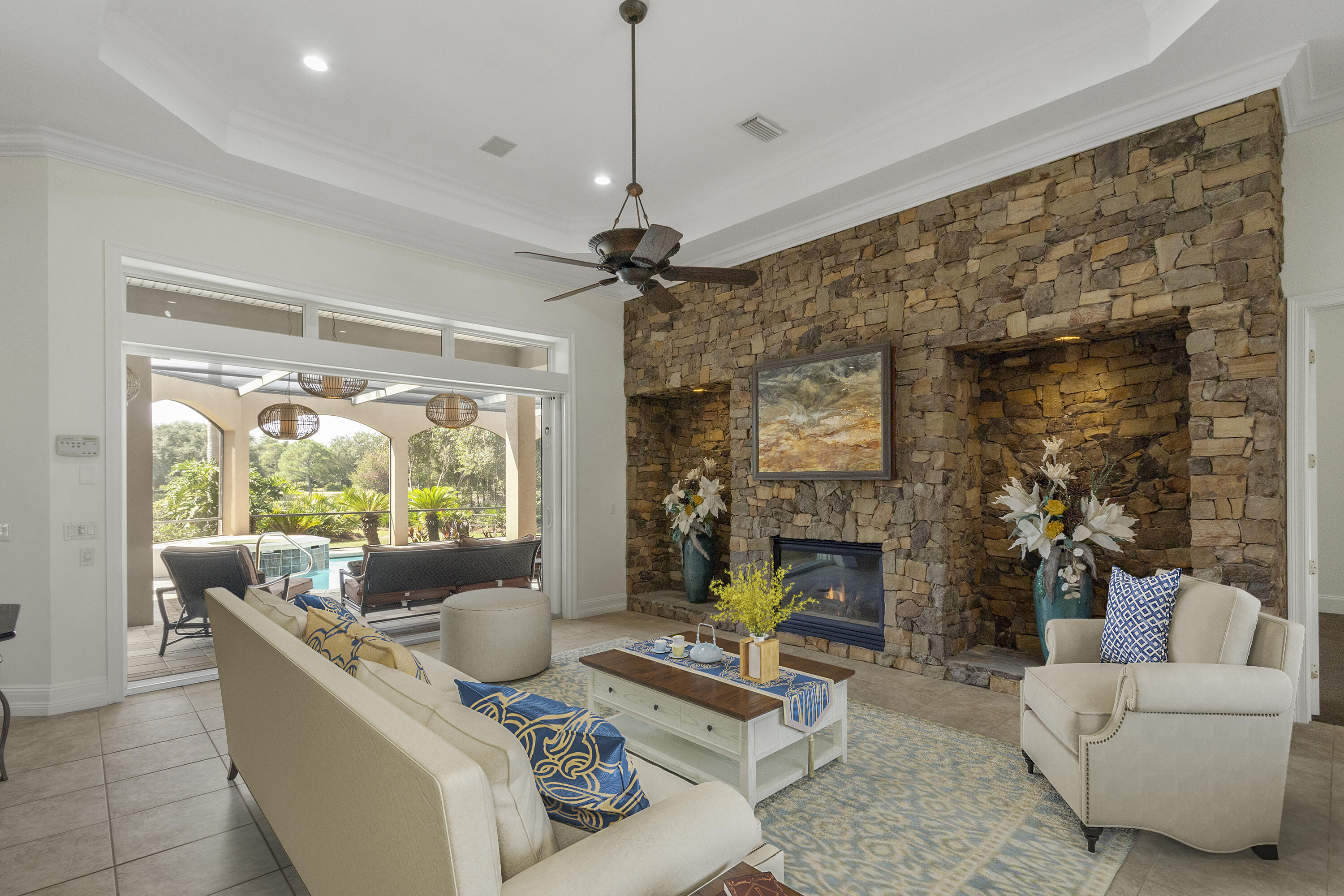 4304 Stonebridge Road Destin, FL 32541 - Photo 20 of 72 a living room with furniture a fireplace and a chandelier