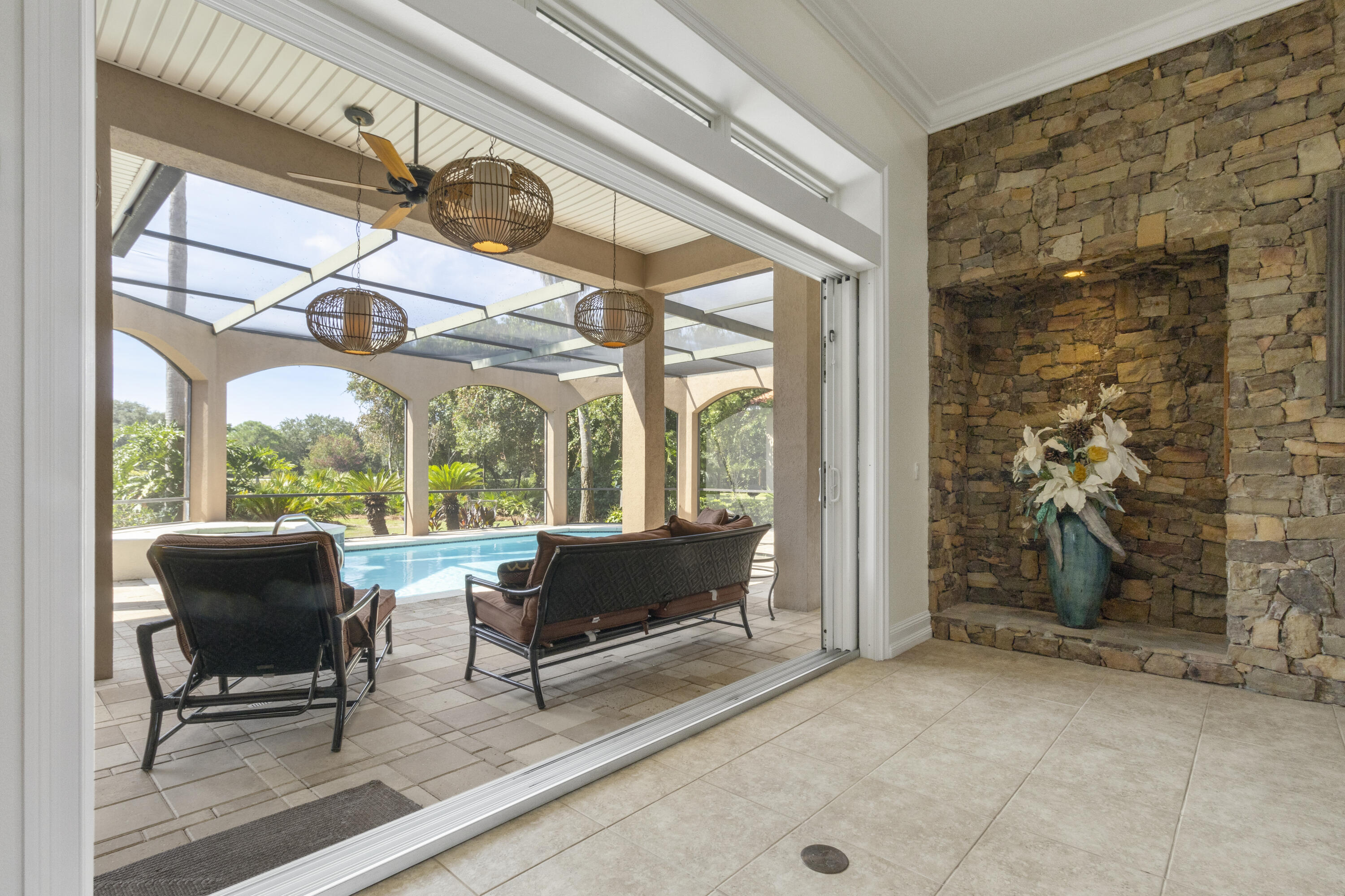 4304 Stonebridge Road Destin, FL 32541 - Photo 23 of 72 a living room with fireplace furniture and a floor to ceiling window