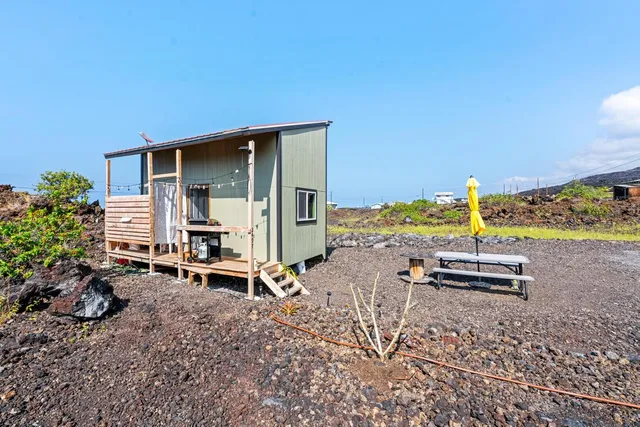 a wooden bench sitting in backside of a house
