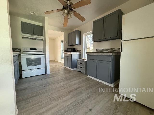 902 East Main Street Weiser, ID 83672 - Photo 14 of 45 Kitchen featuring gray cabinetry, white appliances, ceiling fan, and light wood-style floors