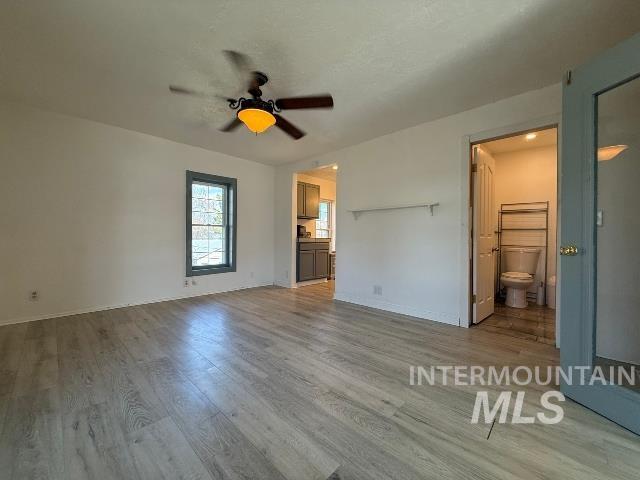 902 East Main Street Weiser, ID 83672 - Photo 24 of 45 Unfurnished bedroom with ensuite bathroom, light wood finished floors, and ceiling fan