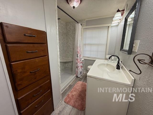 902 East Main Street Weiser, ID 83672 - Photo 29 of 45 Full bathroom featuring vanity, a textured wall, a shower stall, and light wood-type flooring