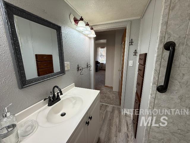 902 East Main Street Weiser, ID 83672 - Photo 31 of 45 Bathroom with a textured ceiling, vanity, light wood-type flooring, and a textured wall