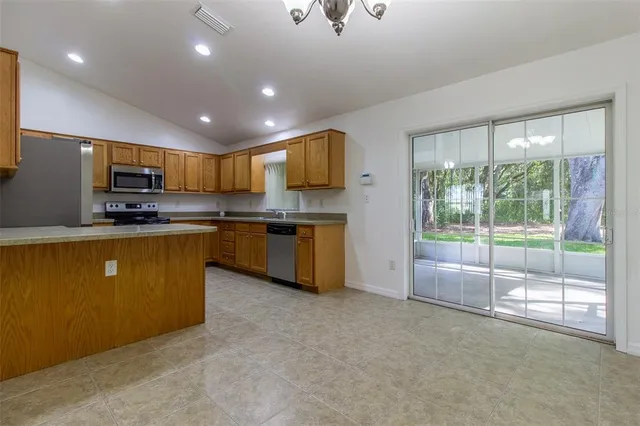 a kitchen with stainless steel appliances granite countertop a stove a sink dishwasher and a refrigerator with cabinets