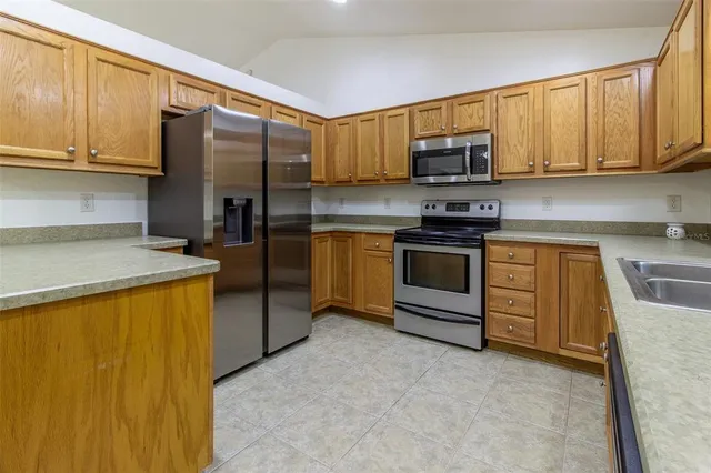 a kitchen with stainless steel appliances granite countertop a stove a microwave and a sink