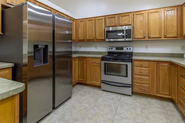 a kitchen with stainless steel appliances granite countertop a sink a stove and microwave