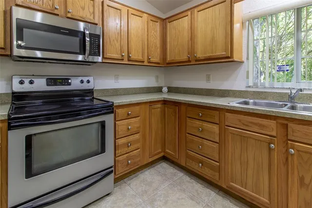 a kitchen a sink a window and cabinets