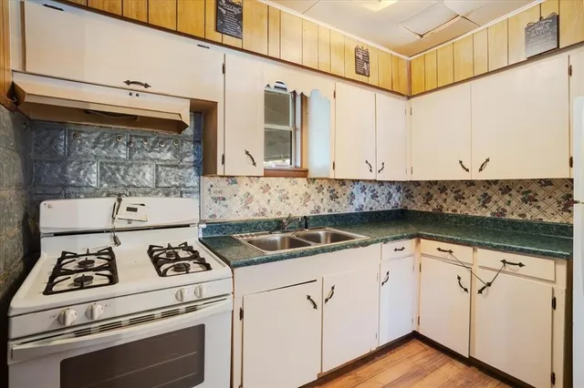 a white kitchen with granite countertop stainless steel appliances