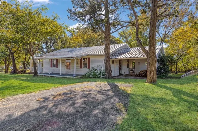 a front view of a house with a yard and trees