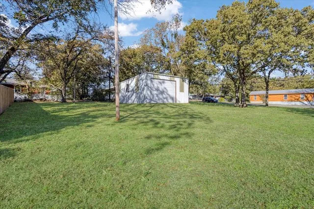 a green field with lots of trees in the background