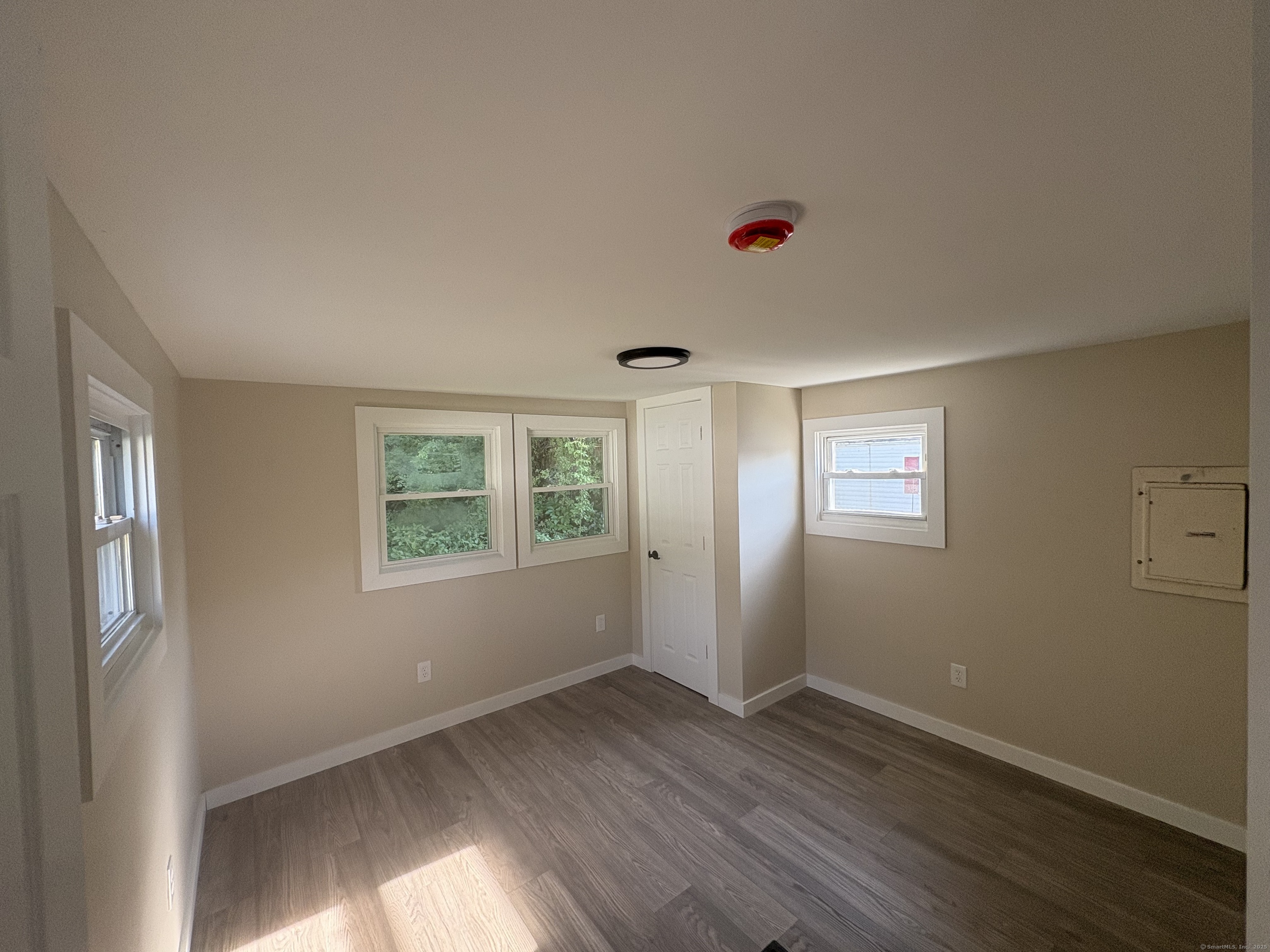 69 Nancy Lane Naugatuck, CT 06770 - Photo 6 of 10 an empty room with wooden floor and windows