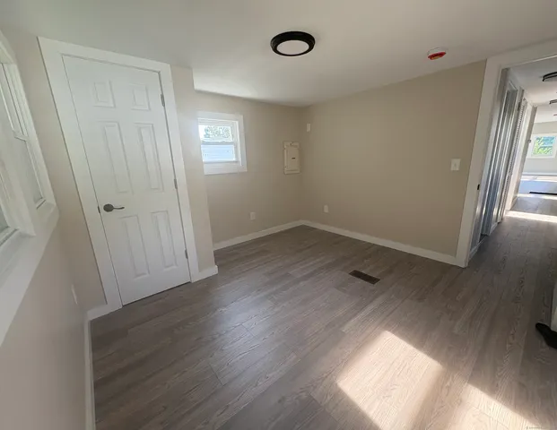 an empty room with wooden floor and window