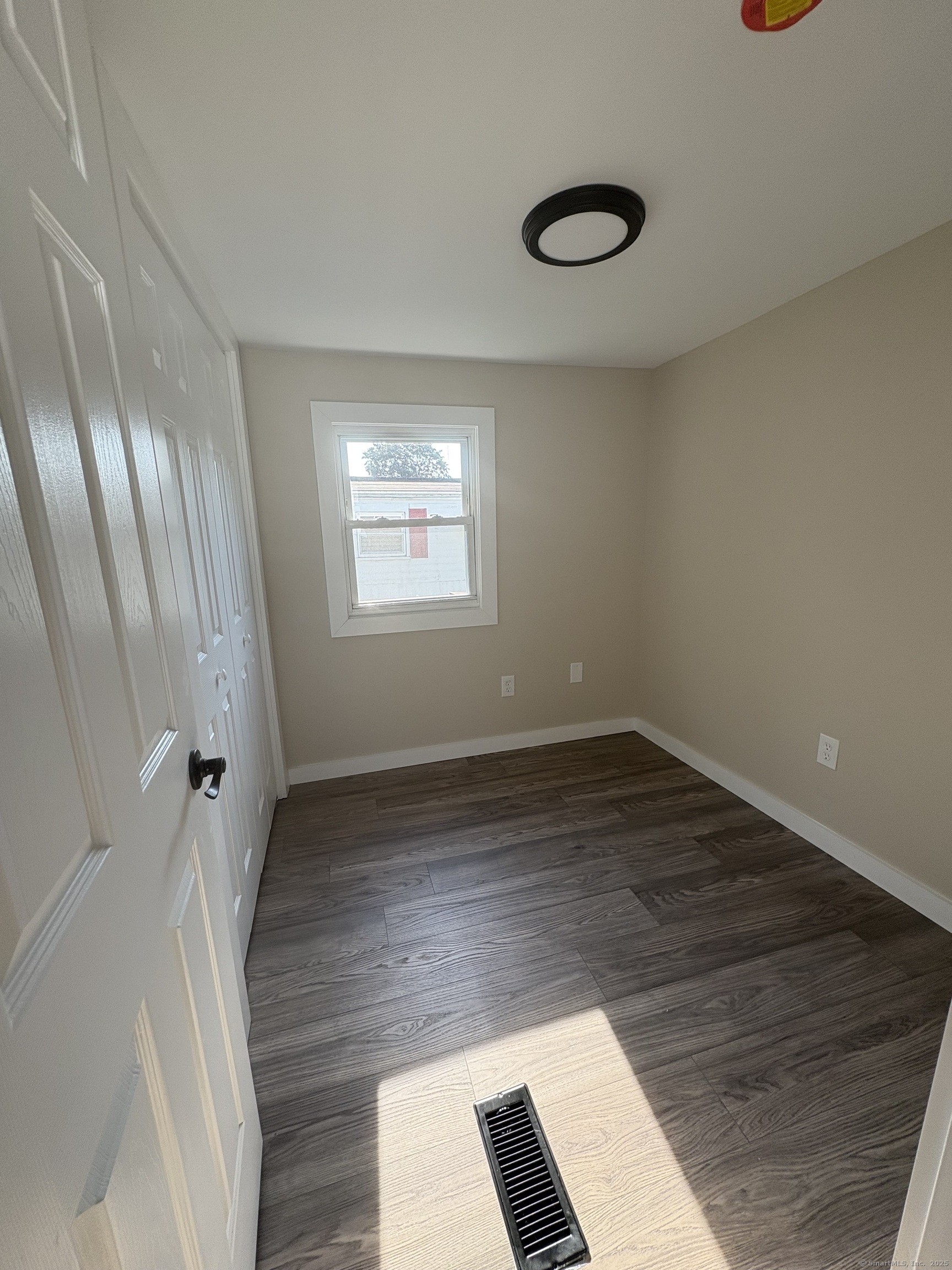 69 Nancy Lane Naugatuck, CT 06770 - Photo 8 of 10 a view of an empty room with wooden floor and windows