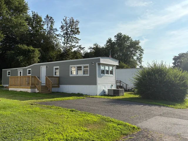 a front view of a house with a yard and trees