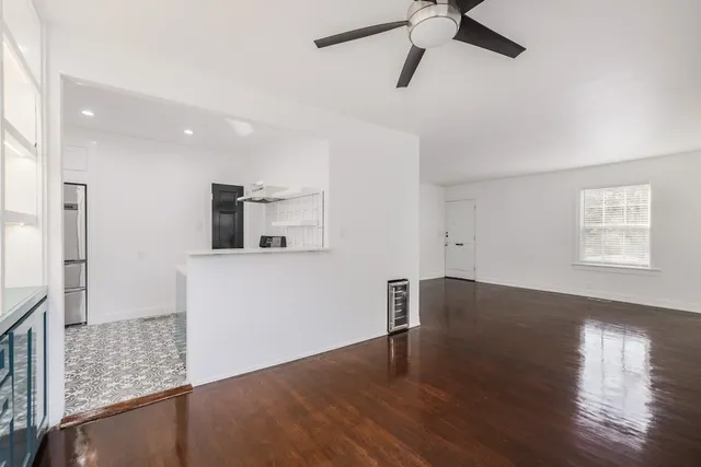 a view of a kitchen with wooden floor and a ceiling fan