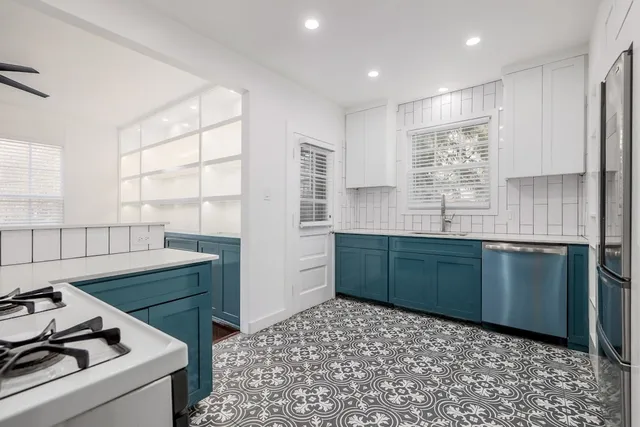 a kitchen with stainless steel appliances kitchen island granite countertop a sink and wooden cabinets