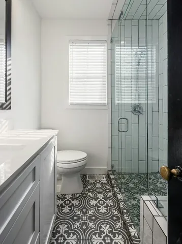 a bathroom with a sink a toilet and shower