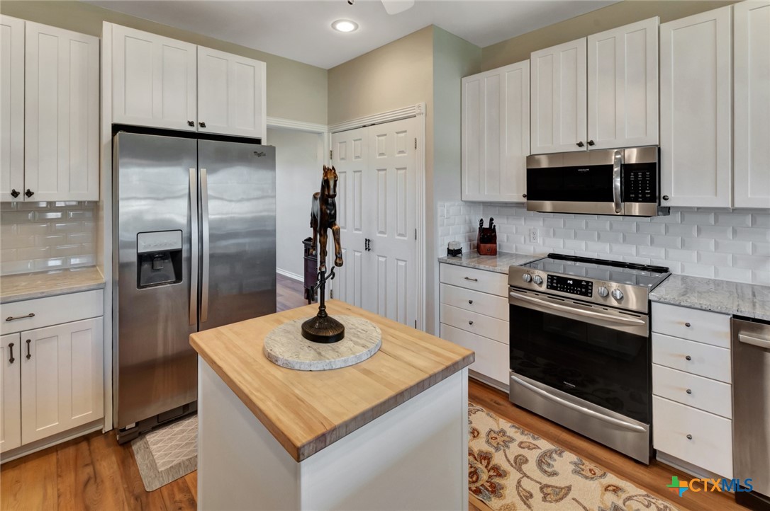 202 Prairie View Road Victoria, TX 77904 - Photo 12 of 47 a kitchen with stainless steel appliances granite countertop a refrigerator a stove and a sink with wooden floor