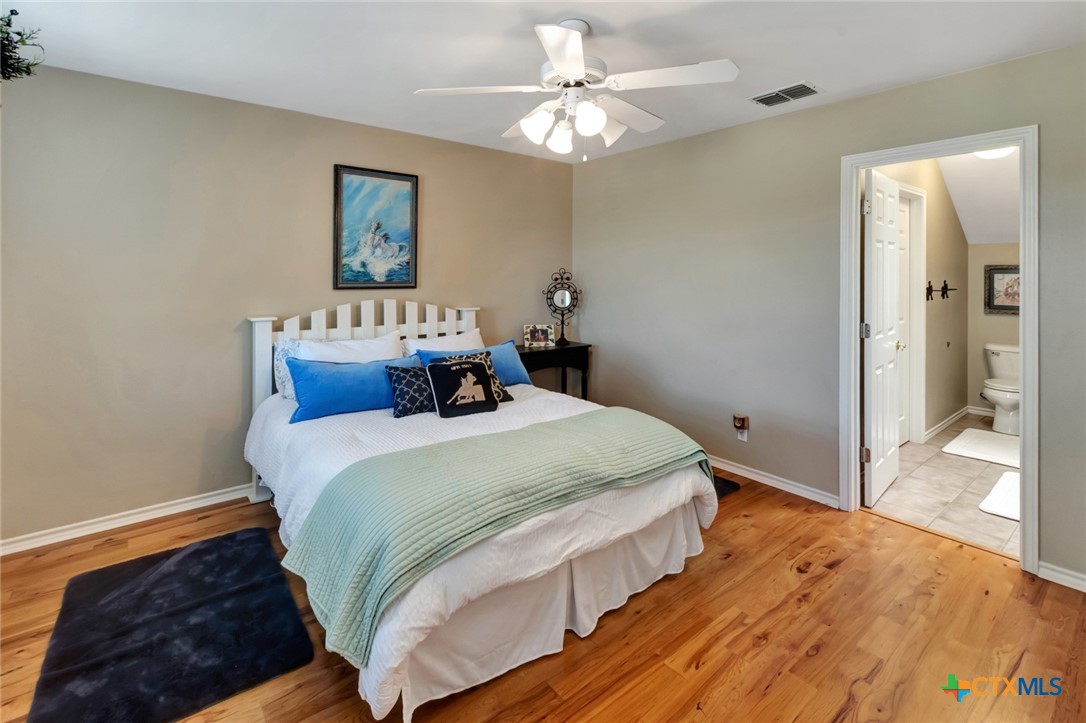 202 Prairie View Road Victoria, TX 77904 - Photo 24 of 47 a bedroom with a large bed and a chandelier