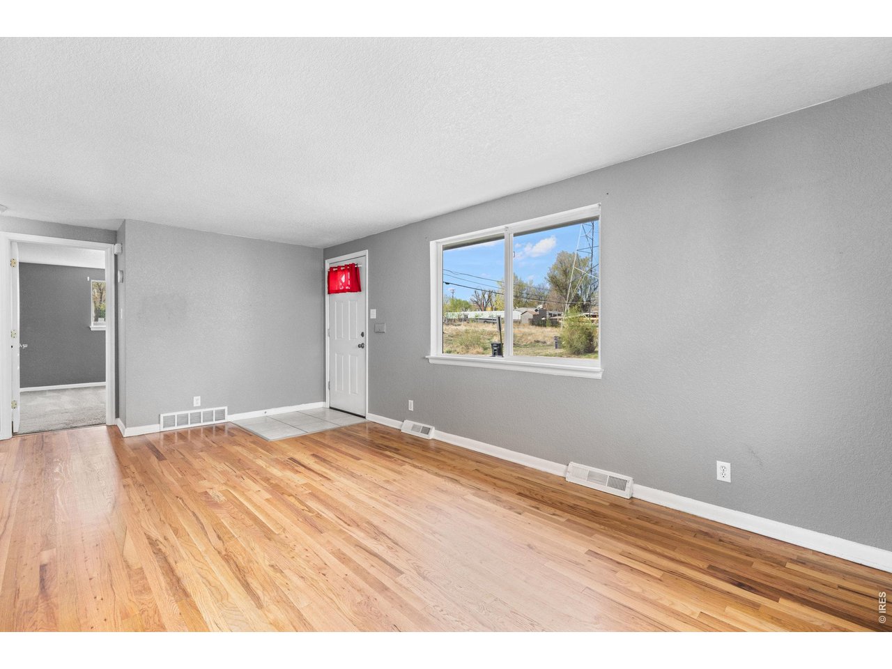 840 South Stuart Street Denver, CO 80219 - Photo 4 of 26 a view of an empty room with wooden floor