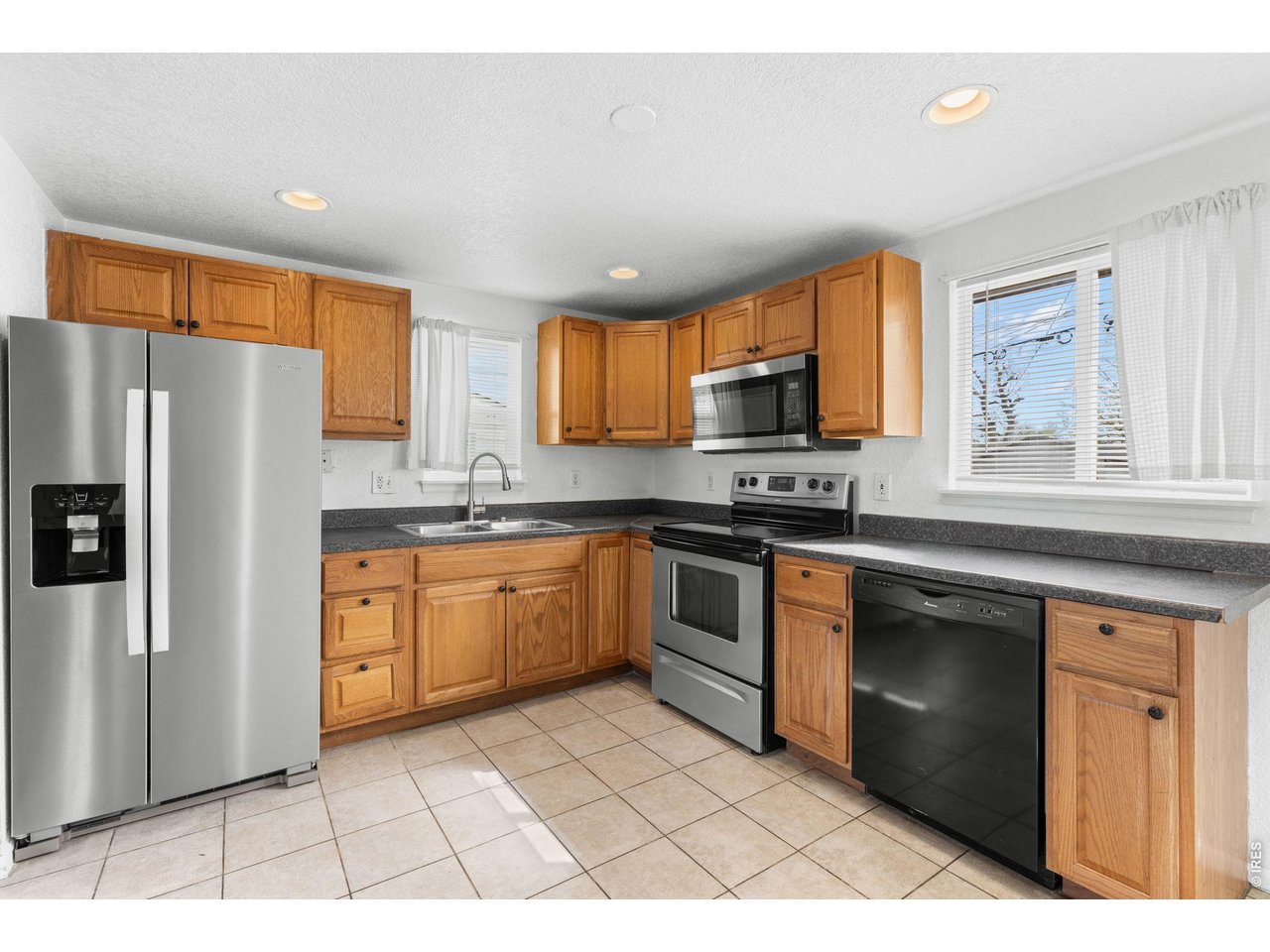 840 South Stuart Street Denver, CO 80219 - Photo 7 of 26 a kitchen with stainless steel appliances granite countertop a stove a sink and a refrigerator