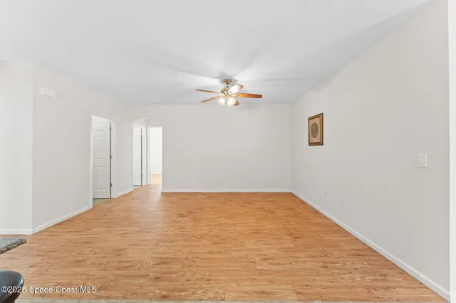 a view of a big room with wooden floor and a ceiling fan