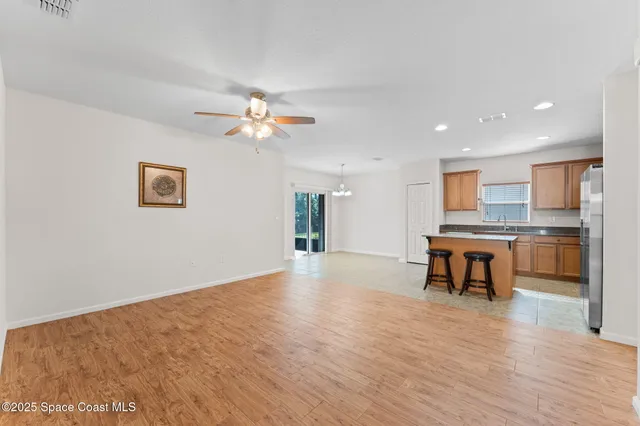 a view of an empty room with window and chandelier