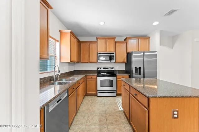 a kitchen with stainless steel appliances granite countertop a sink stove and refrigerator