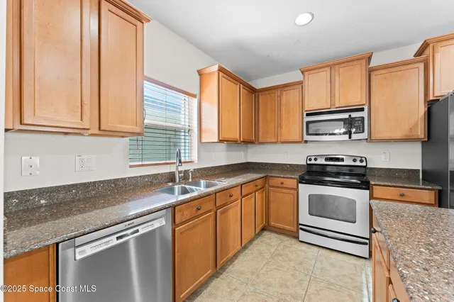 a kitchen with stainless steel appliances granite countertop a sink stove and microwave