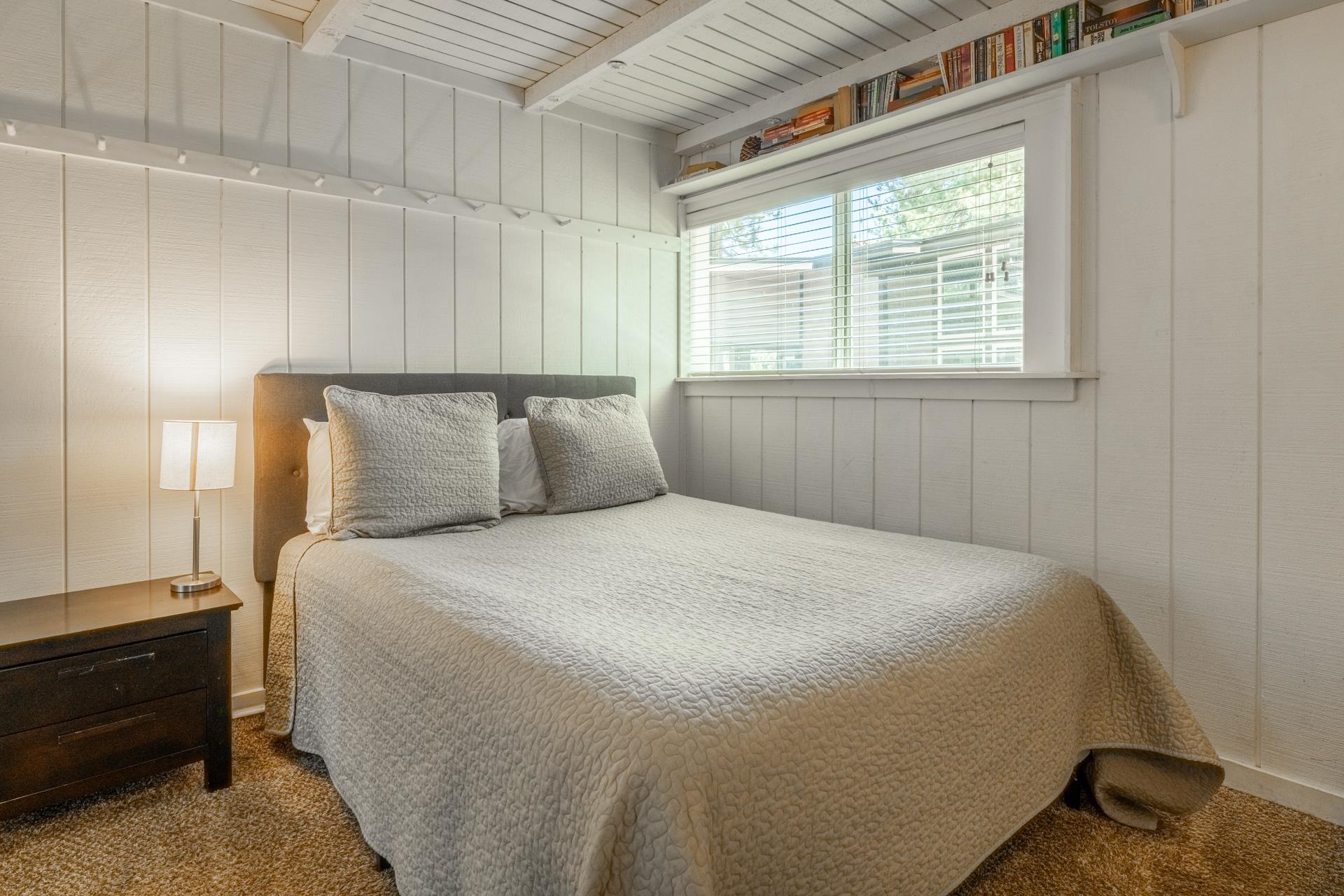 165 Old Mammoth Road, Unit 3 Mammoth Lakes, CA 93546 - Photo 27 of 48 White vertical paneling walls, exposed beam ceiling, built-in shelving, window with blinds, and textured carpeting