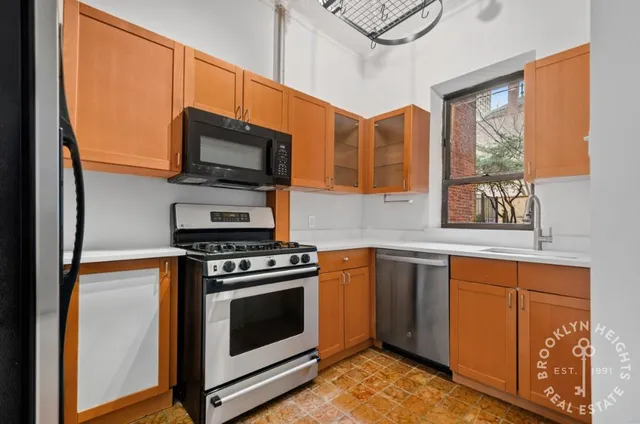 a kitchen with stainless steel appliances granite countertop a stove microwave and sink