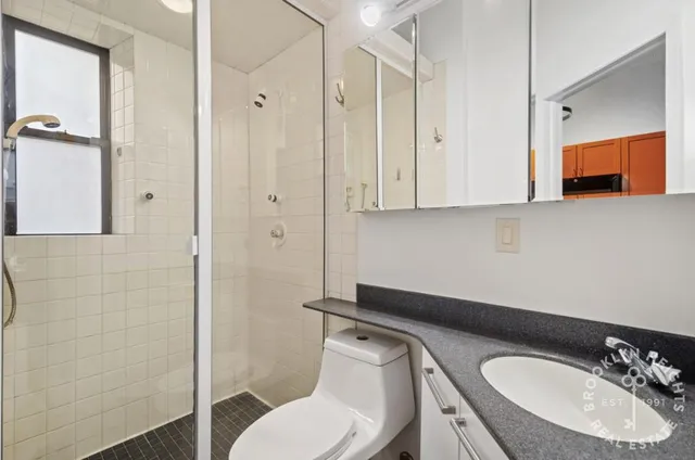 a bathroom with a toilet a sink and mirror