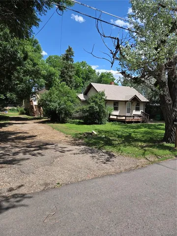 a view of a house with a yard and large trees