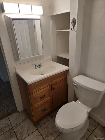 a bathroom with a toilet a sink and mirror