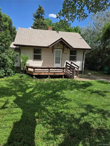 a aerial view of a house with table and chairs under an umbrella