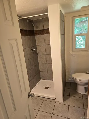a bathroom with a toilet and a shower