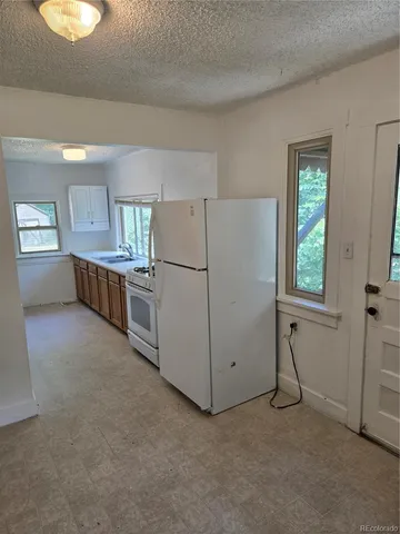 a kitchen with refrigerator and window