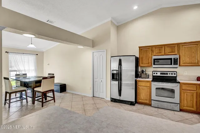 a view of a kitchen with kitchen island a sink wooden floor and a refrigerator