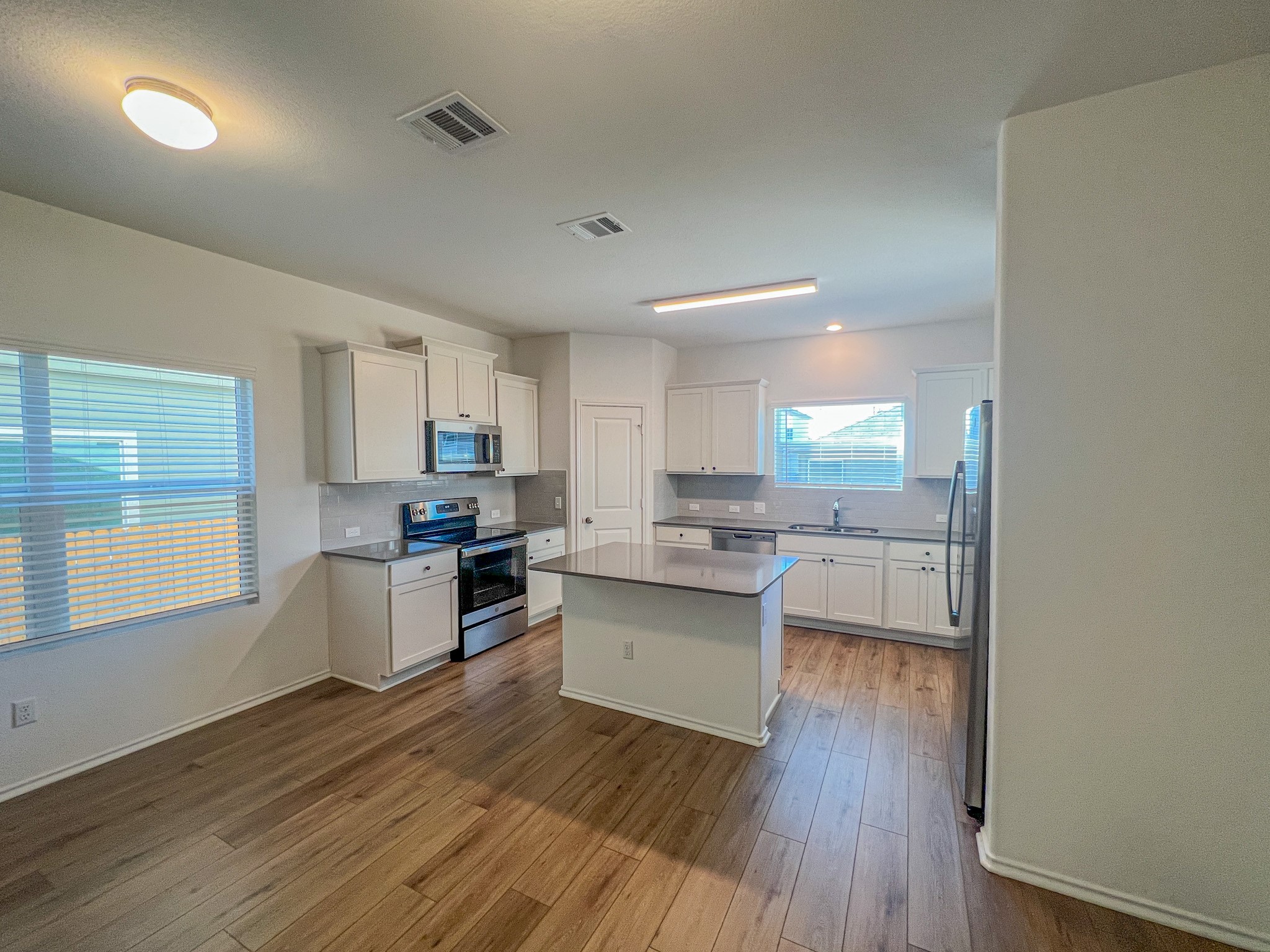 438 Perfect World Loop Jarrell, TX 76537 - Photo 4 of 35 a kitchen with sink cabinets and wooden floor