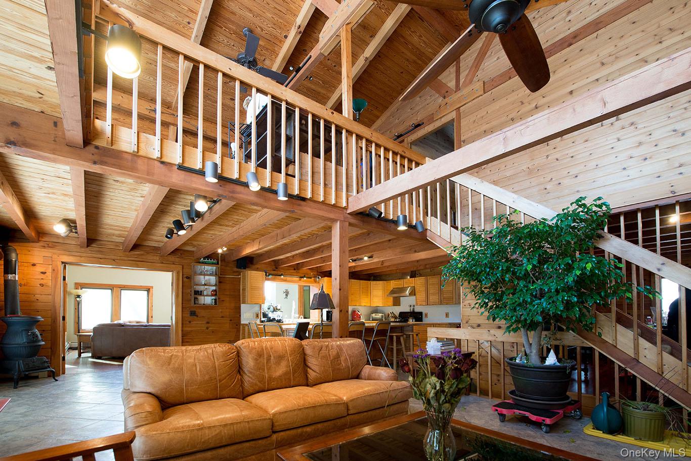1644 Lakes Road Monroe, NY 10950 - Photo 8 of 50 Living area featuring wood walls, a ceiling fan, a wood stove, and a high wooden ceiling