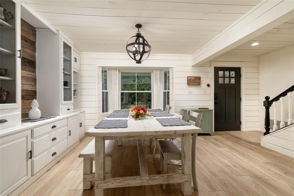 8948 David Fort Road Argyle, TX 76226 - Photo 8 of 39 Spacious dining area featuring white shiplap walls, wood-finish flooring, and a large bay window
