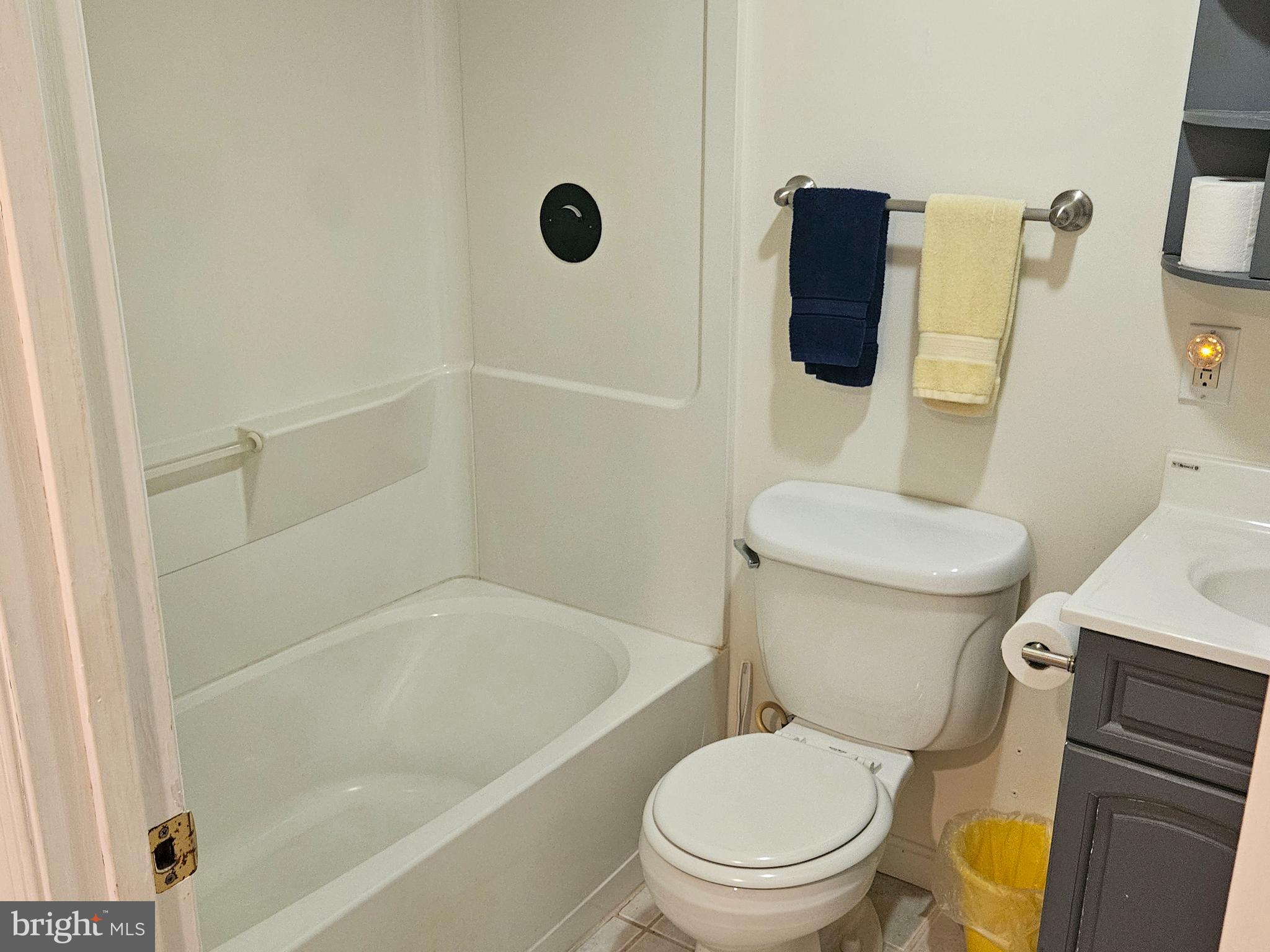 6907 Belclare Road Baltimore, MD 21222 - Photo 16 of 26 a white toilet sitting next to a bath tub