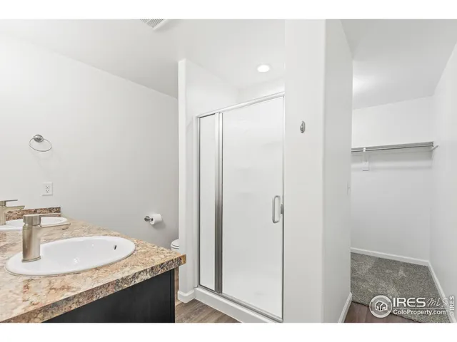 a bathroom with a granite countertop sink a mirror and a shower