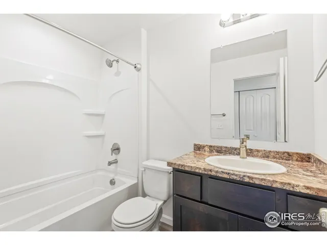 a bathroom with a granite countertop sink mirror toilet and bathtub