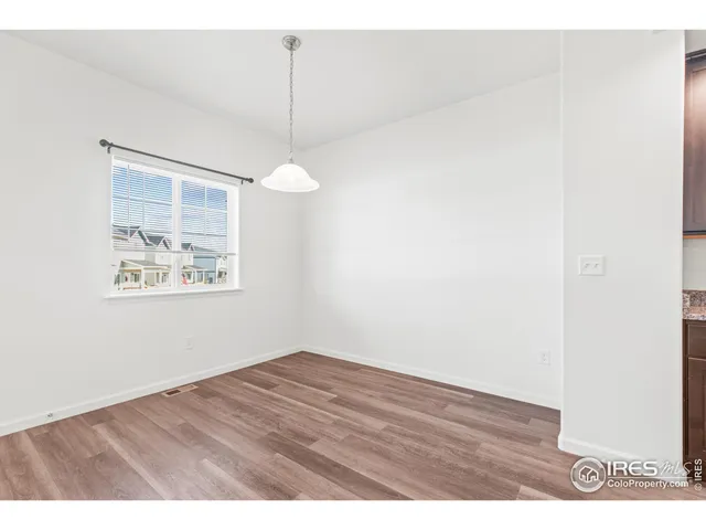 a view of an empty room with a window and a ceiling fan