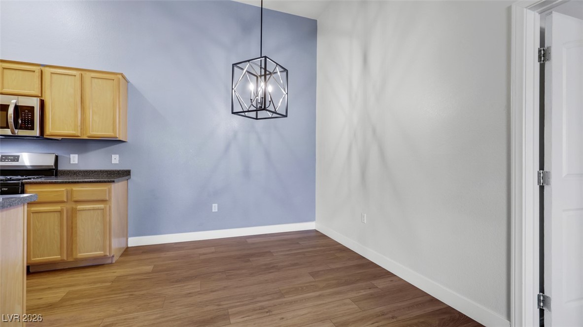 2305 West Horizon Ridge Parkway, Unit 1224 Henderson, NV 89052 - Photo 5 of 26 Unfurnished dining area with light wood finished floors and a chandelier