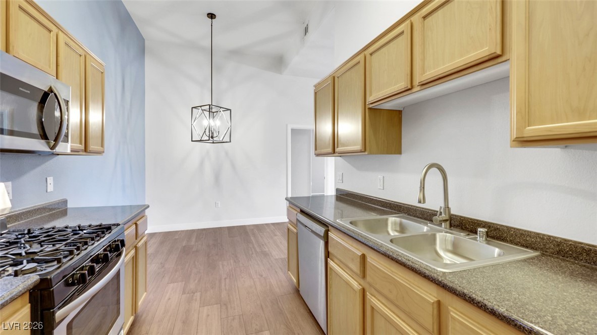 2305 West Horizon Ridge Parkway, Unit 1224 Henderson, NV 89052 - Photo 9 of 26 Kitchen with appliances with stainless steel finishes, light wood-style floors, light brown cabinetry, and decorative light fixtures