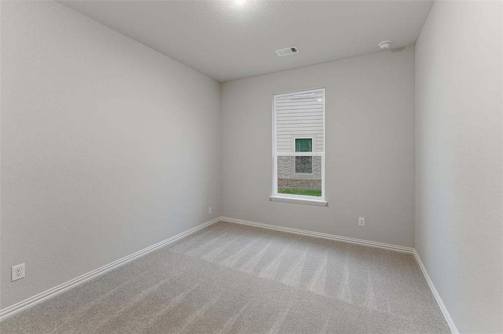 1237 Frio Drive Springtown, TX 76082 - Photo 12 of 25 Neutral tone walls and carpeting throughout a room featuring a single window with blinds, baseboard trim, and a ceiling-mounted light fixture