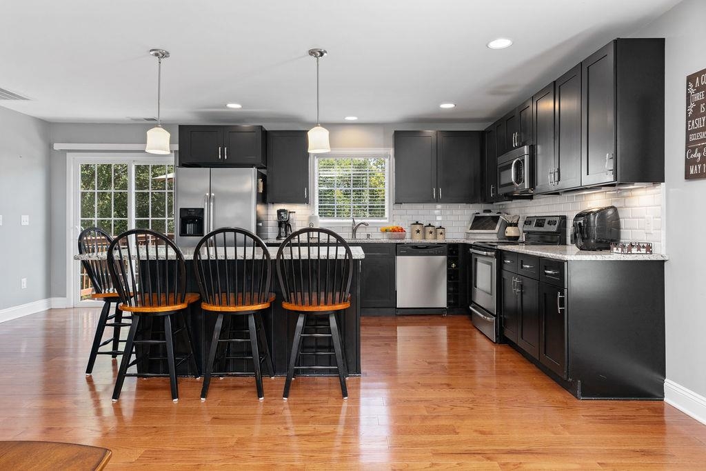 15 Rolla Mill Road Verona, VA 24482 - Photo 13 of 73 a kitchen with stainless steel appliances granite countertop a stove top oven a sink a dining table and chairs with wooden floor
