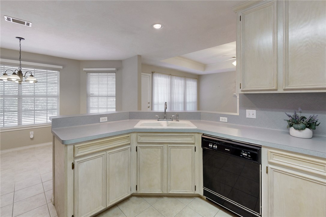 5901 Sheffield Terrace Lane Bryan, TX 77802 - Photo 9 of 31 Kitchen featuring light stained cabinets, stainless steel and black appliances, light tile flooring, ample countertop space for food prep and serving